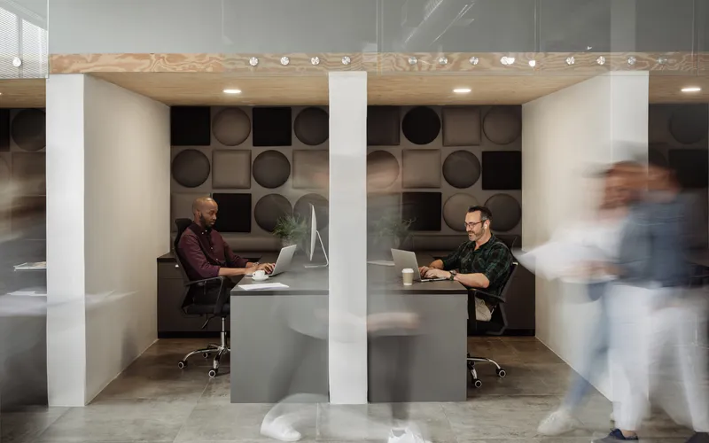 Symbolbild Software Success Story, Menschen im modernen Workspace arbeiten an ihren Laptops